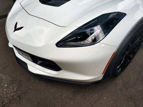 Chevrolet Corvette Stingray car, front side view. Part of white stylish american sports car