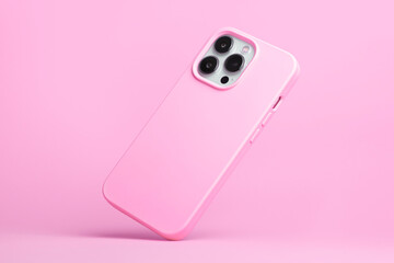 iPhone 14 pro max and 13 in pink soft silicone case falls down back view, phone case mockup in monochrome colours isolated on pink background