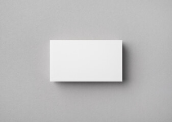 Blank business card on gray paper background. Mock-up for branding identity. Flat lay.