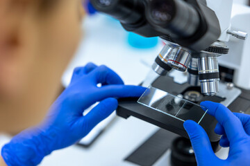 Unrecognizable scientist working in laboratory, doctor using microscope analysis slides