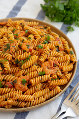 Homemade Creamy Tomato Shrimp Rotini Pasta with Parsley on a Plate, side view. Close-up.