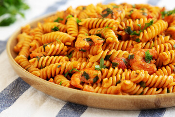 Homemade Creamy Tomato Shrimp Rotini Pasta with Parsley on a Plate, low angle view. Close-up.