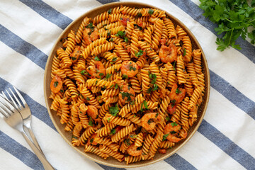 Homemade Creamy Tomato Shrimp Rotini Pasta with Parsley on a Plate, top view. Flat lay, overhead, from above.