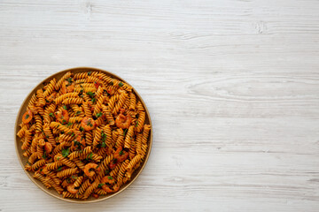 Homemade Creamy Tomato Shrimp Rotini Pasta with Parsley on a Plate, top view. Flat lay, overhead, from above. Copy space.