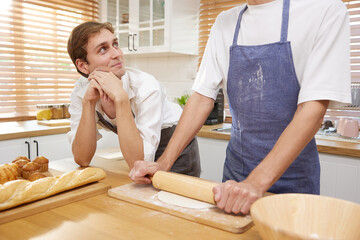 LGBT gay couple making a bread together in the kitchen