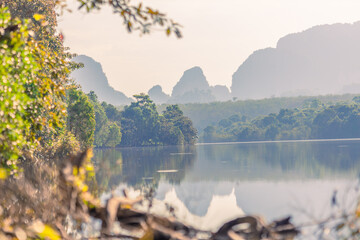Natural background of a large reservoir in Krabi,Thailand(Nong Thale)atmosphere surrounded by mountains,trees of various sizes, blown through the wind,blurred cool during the day,a viewpoint of travel