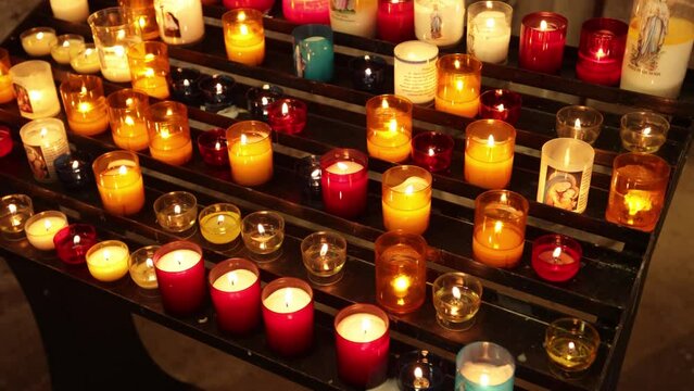 bougies allum&eacute;es sur un pr&eacute;sentoir &agrave; l'int&eacute;rieur d'une &eacute;glise