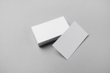 Blank white business cards on gray paper background. Mockup for branding identity.