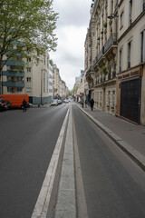 Fototapeta na wymiar Paris, France - 05 01 2023: Ourcq canal. View of a long downhill street and a clean site bike lane.