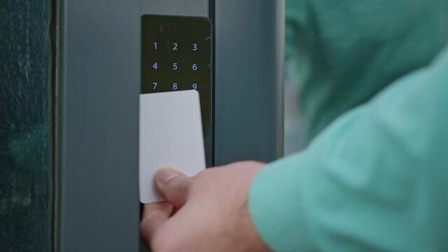 Close-up of people applying a white plastic key card to an electronic lock. Modern security system. 