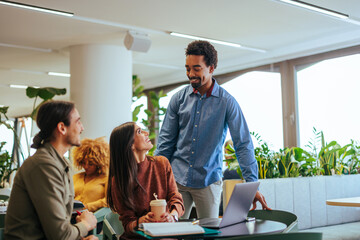 Cheerful coworkers discussing on coffee break.
