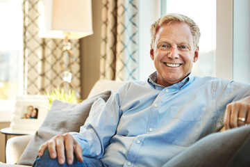 Nothing as enjoyable as a relaxed retirement. Portrait of a happy mature man relaxing on the sofa at home.