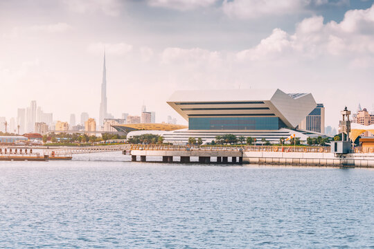 19 January 2023, Dubai, UAE: Mohammed bin Rashid library in shape of open book on a seashore and Burj Khalifa spire in the background