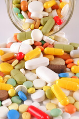A bunch of colorful pills, capsules, poured out of a jar. Production and disposal of...