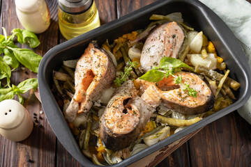 Low carb dinner, healthy nutrition concept, diet menu. Healthy baked fish salmon steaks with basil, green beans and sweet peppers on a rustic table.