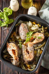 Low carb dinner, healthy nutrition concept, diet menu. Healthy baked fish salmon steaks with basil, green beans and sweet peppers on a rustic table.