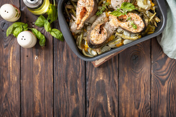 Healthy baked fish salmon steaks with basil, green beans and sweet peppers on a rustic table. Low carb dinner, healthy nutrition concept, diet menu. View from above. Copy space.