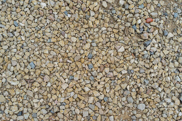 imagen detalle textura suelo de piedras de distintos tama&ntilde;os y colores con una tonalidad c&aacute;lida 