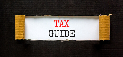 Tax guide symbol. Concept words Tax guide on beautiful white paper. Beautiful black paper cardboard background. Business and Tax guide concept. Copy space.