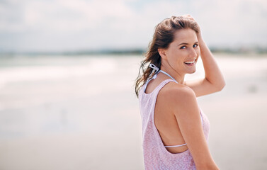 Loving the fresh air. Portrait of an attractive woman enjoying a day at the beach.