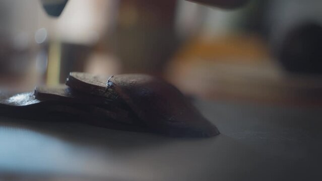 Cooked beets are sliced on a mandoline slicer. Slow motion, shallow depth of field. 