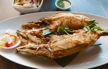 fried fish with spicy salad vegetable on white dish. top view