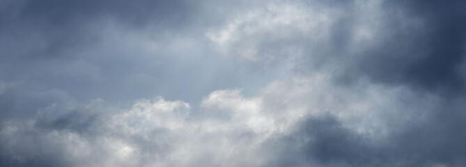 Obraz premium Thunderstormy sky with gray clouds, sunlight barely penetrates through the dark clouds