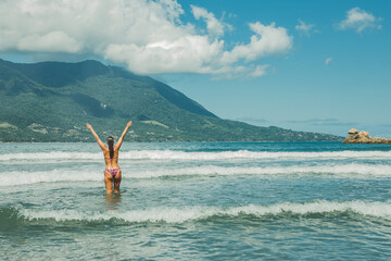 Mulher de braços abertos no mar da praia