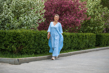 Portrait of a young beautiful blonde woman in blue dress