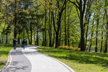 People taking a stroll in the park on a sunny day.