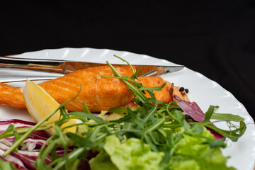 Salmon steak with salad and lemon