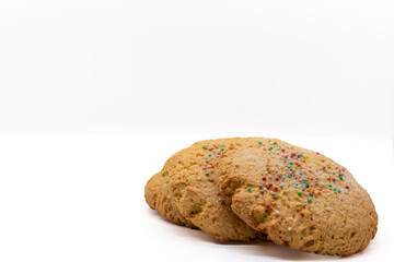 Cookies with colored sprinkles isolated on white background, selective focus