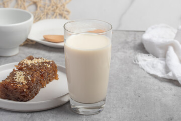 Hot fresh milk in transparent glass on gray background