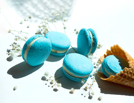 French blue macarons on light background with flowers. Close-up
