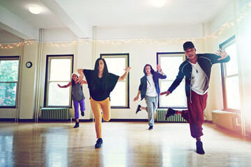 Practicing for the top spot in the dance championships. a group of young people dancing together in a studio.