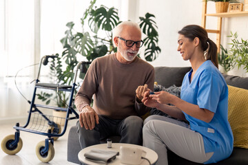 Confident good looking senior man talking to female nurse while getting his blood sugar measured...