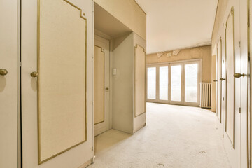 an empty room with white walls and beige door handles on the doors are open to reveal another room that is in need of renovation