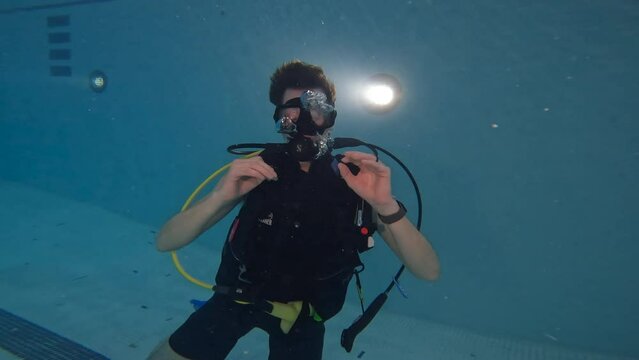 Scuba diver gives o.k hand single while training in swimming pool