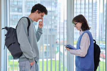 Talking laughing college students, guy and girl with backpacks