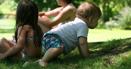 Family outside in home lawn, baby exploring world crawling