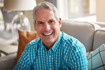 Retirement, you gotta love it. Portrait of a happy mature man relaxing on the sofa at home.