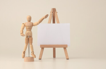 Empty copy space paper canvas on small wood easel. Art Light beige background.