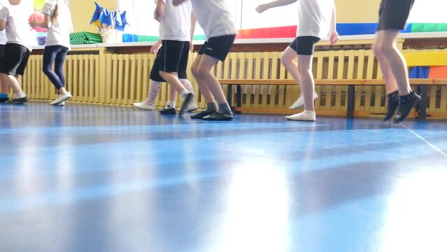 Group of elementary students exercising during class at school gym. Kids running in kindergarten gym. Children training with sport equipment. boys and girls exercising in sport club. 4 k video