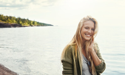 Theres plenty of smiles to be made in nature. a young woman spending a day at the lake.