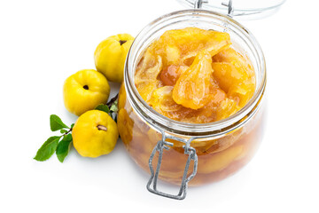 Homemade quince jam in glass jars and fresh quince with leaves isolated on white