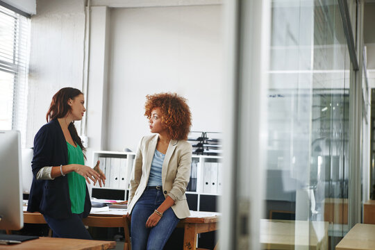 Lets go over the details. two young female designers discussing work in the office.