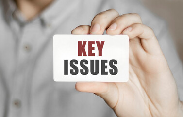 Card with text Key Issues in a man's hand