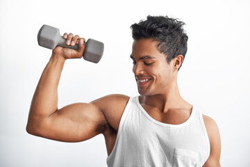 Proud of his accomplishments. A fitness shot of an athletic young man lifting a dumbbell.