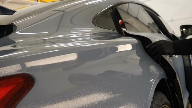 Close up to PPF installation process on a front headlight and hood. PPF is a Paint Protection Film which protect paint from scratches and stone chips. Concept of: Guard, Protect, Car, New, Work.	
