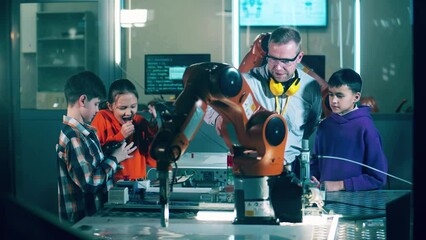Male instructor is demonstrating robots to the children